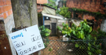 A imagem mostra uma residência em São Sebastião situada em área de risco. Há, à frente, uma marcação feita pela equipe da CDHU.