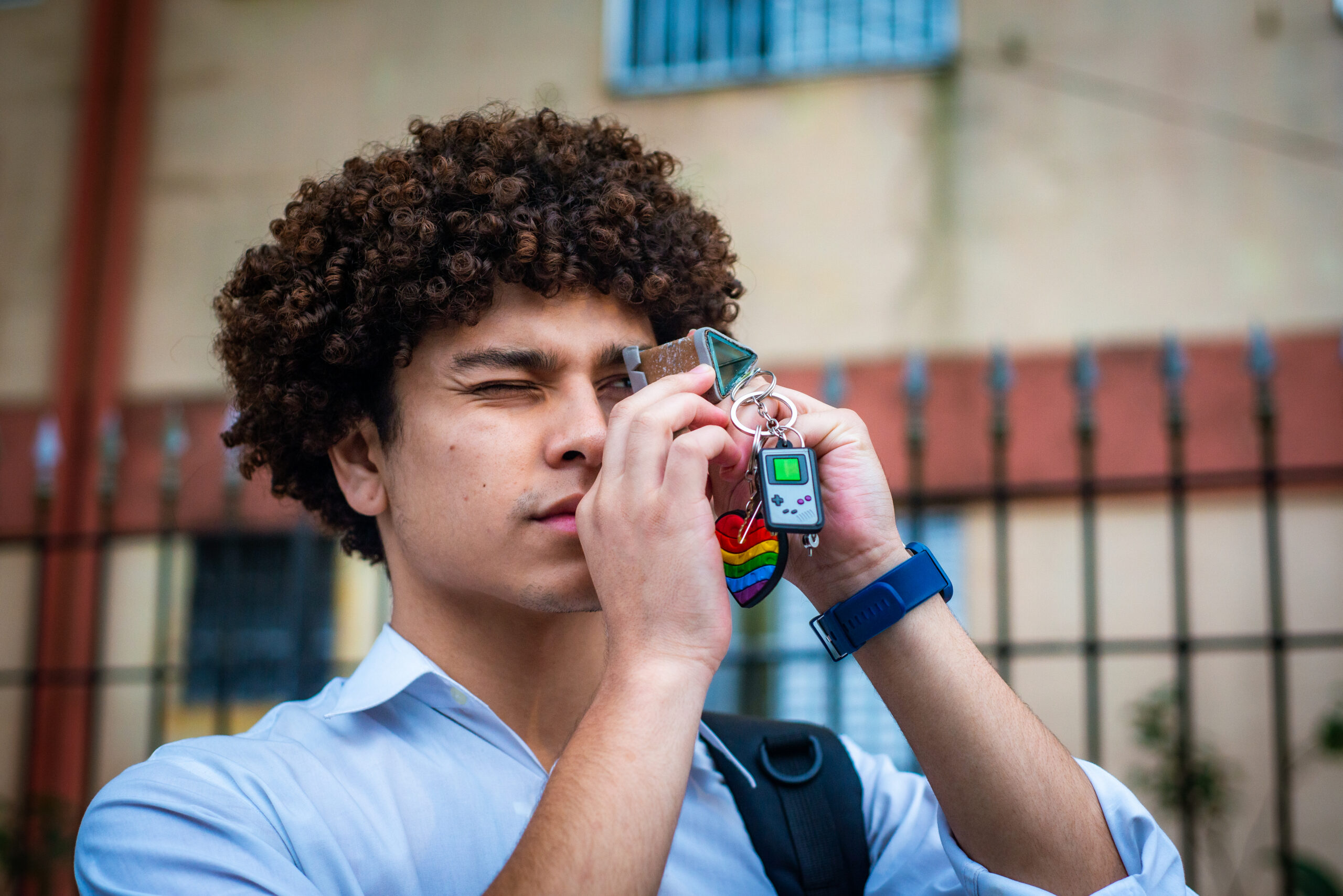 Cena do curta-metragem 'Sem Tempo, Irmão' na qual o personagem Sérgio olha para dentro de um caleidoscópio. O personagem tem cabelo black power e usa uma camisa branca e uma mochila.