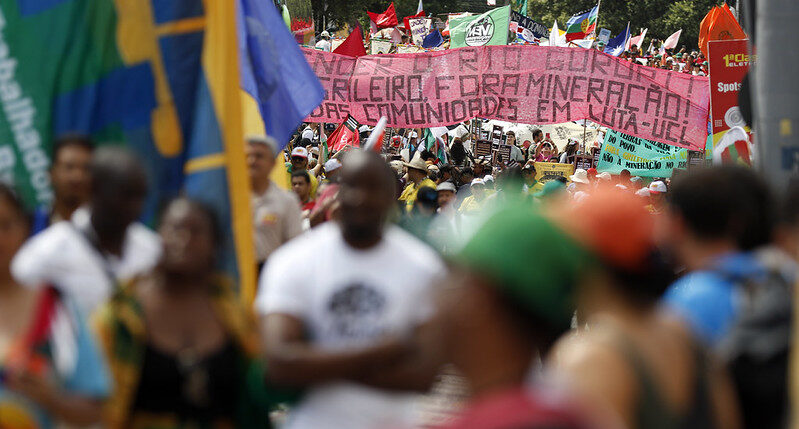 Imagem ilustrativa de texto sobre a importância de mencionar afrodescendentes no combate às mudanças climáticas é fundamental no enfrentamento das desigualdades. A foto mostra manifestantes e faixas reivindicatórias durante a Marcha Global pelo Clima, realizada durante a COP30.