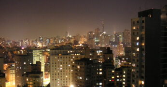 Imagem do horizonte de São Paulo à noite, em que é possível ver prédios com luzes acesas. A foto ilustra o artigo sobre a importância de regionalizar o orçamento.