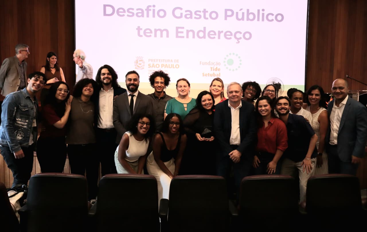 Foto do palco do anfiteatro da Biblioteca Mário de Andrade com integrantes das secretarias vencedoras do III Desafio Gasto Público Tem Endereço.