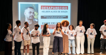 Imagem de integrantes da Fundação Tide Setubal e de Geledés - Instituto da Mulher Negra durante a entrega do troféu de segundo lugar no 4° Prêmio MOL de Jornalismo para a Solidariedade. Todas as pessoas estão com camisetas com a foto de Helber Alves, coapresentador do podcast 'Essa Geração pelo Clima', que está desaparecido desde 24 de dezembro de 2025.