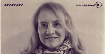 Imagem de Jacqueline Pitanguy. Ela é uma mulher branca, que tem cabelos loiros e usa uma echarpe. A foto tem filtro na cor roxa e os logos da Rádio Novelo e da Fundação Tide Setubal.