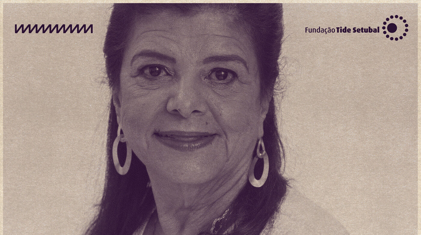 Imagem de Luiza Trajano. Ela é uma mulher branca, que tem cabelos castanhos e usa par de brincos em formato oval. A foto tem filtro na cor roxa e os logos da Rádio Novelo e da Fundação Tide Setubal.