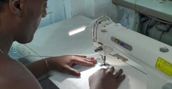 Imagem de uma pessoa usando uma máquina de costura. Trata-se de imagem de uma das aulas do projeto Transforma Trama.