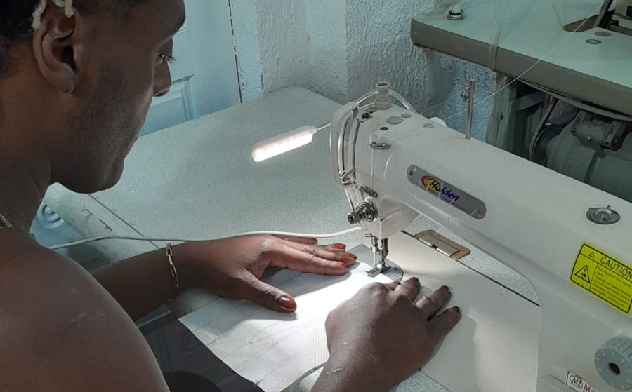 Imagem de uma pessoa usando uma máquina de costura. Trata-se de imagem de uma das aulas do projeto Transforma Trama.