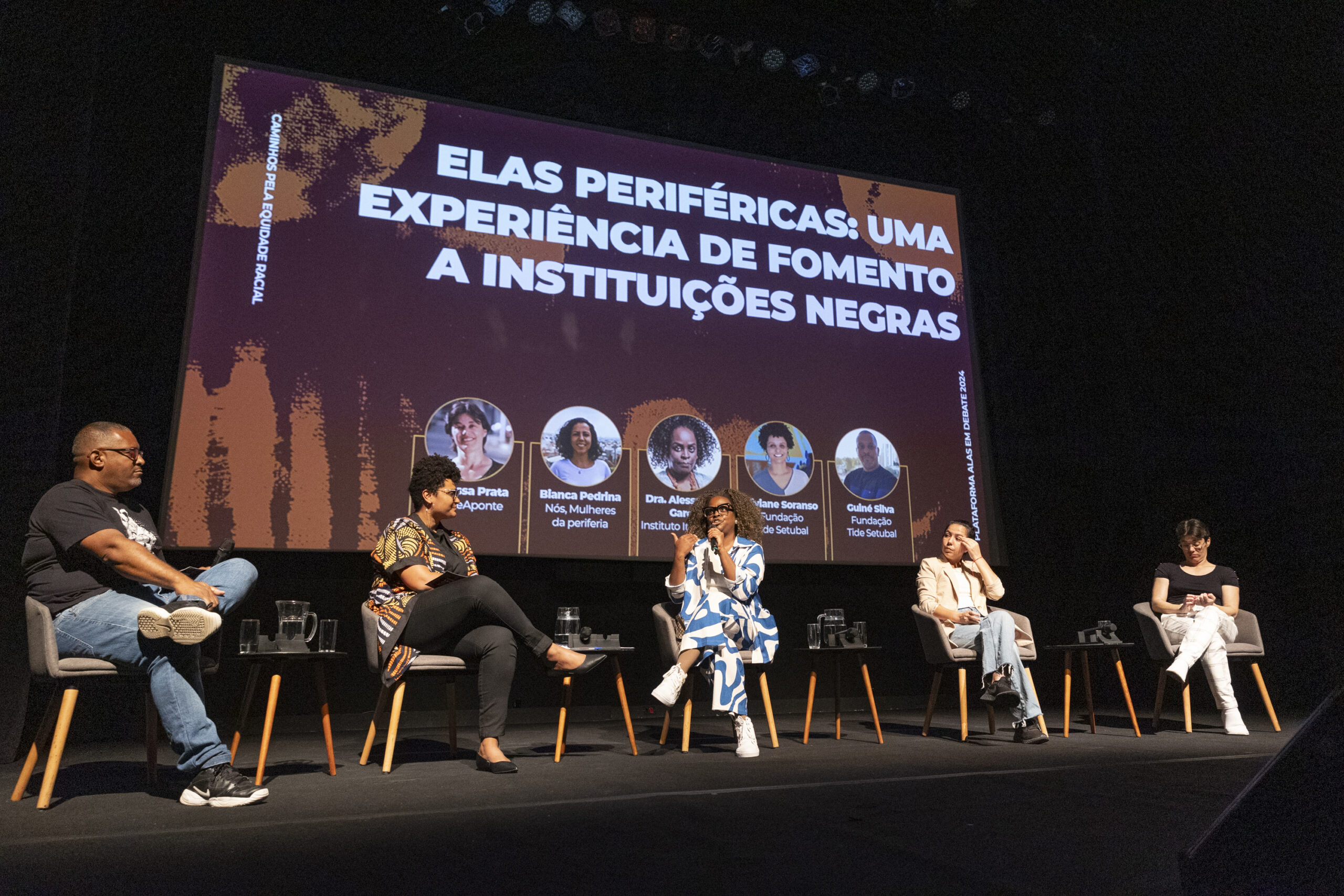 Imagem do evento Plataforma Alas em Debate, de 2024, em que havia cinco pessoas no palco do Itaú Cultural. A imagem ilustra o texto sobre fomento a organizações e lideranças das periferias.