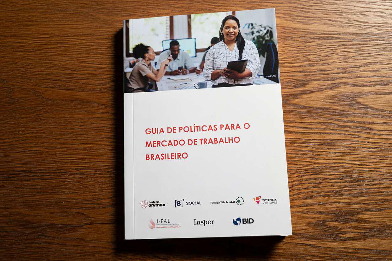 Capa do Guia de Políticas para o Mercado de Trabalho Brasileiro. A ilustração é predominantemente branca e contém, no topo, a foto de um escritório em que há três pessoas ao fundo, sentadas à mesa, e outra à frente, em pé, segurando uma pasta.